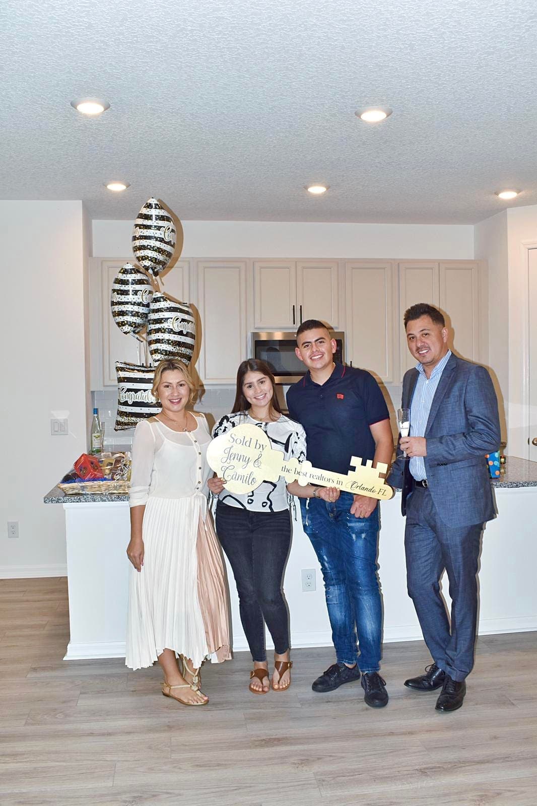 Buyers celebrating with an oversized key and balloons in their new home