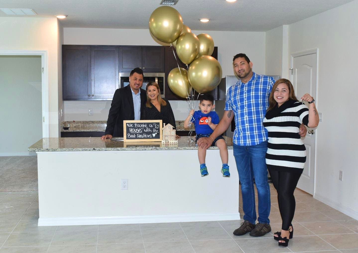 A family at the kitchen island of the Central Florida home they just closed on