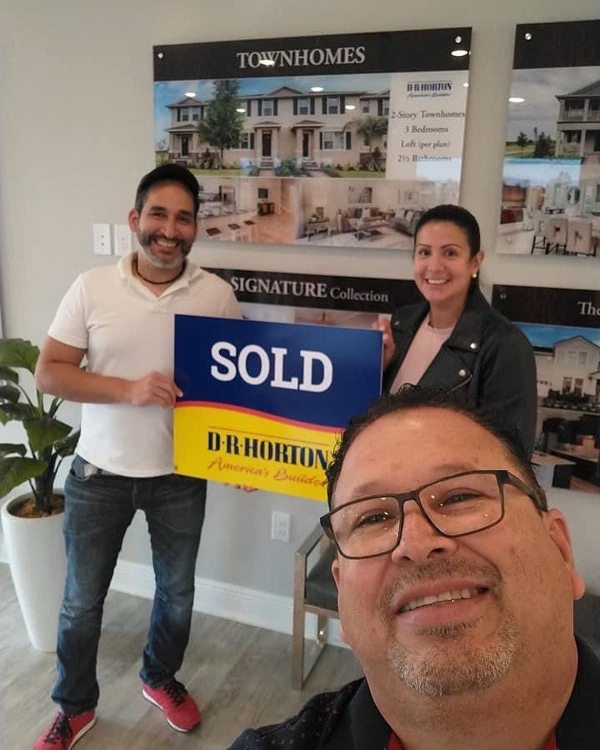 Buyers with the sold sign at their new construction home